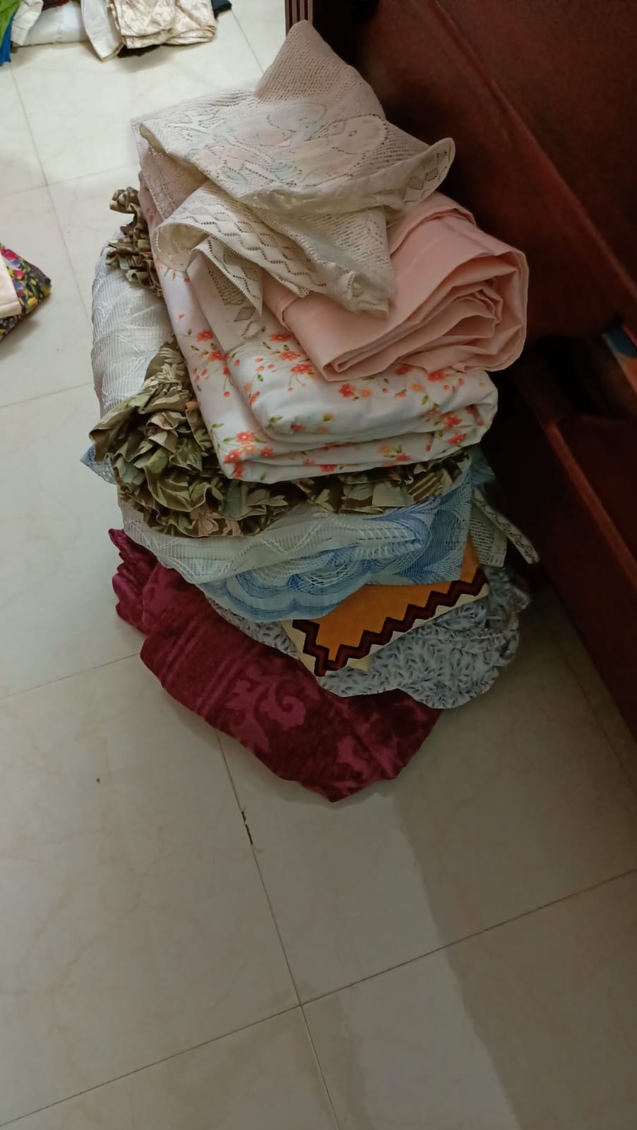 A pile of freshly folded bedsheets and covers, part of the unseen work of running a home