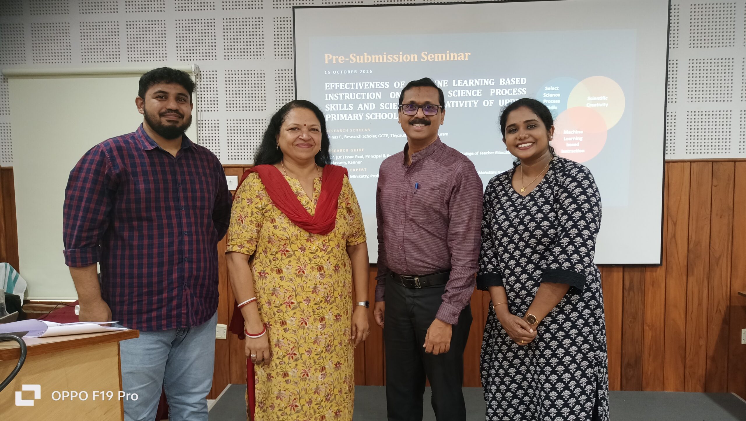 PhD pre-submission seminar at Kariavattom: the author in yellow with research scholar Shinas F., his supervisor Prof. (Dr.) Issac Paul and a fellow scholar, in front of the seminar slide