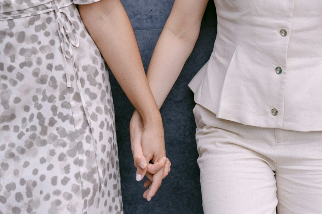 Women who suffer in silence: two women holding hands in comfort and support